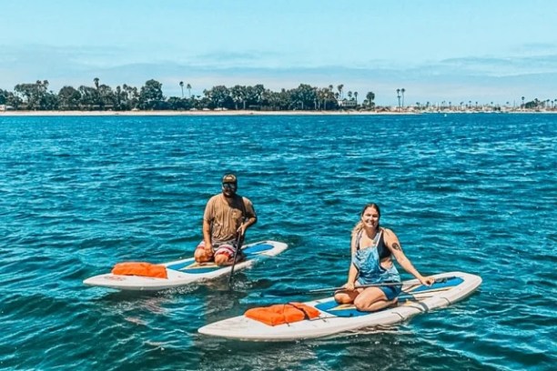 a group of people riding on the back of a boat in the water
