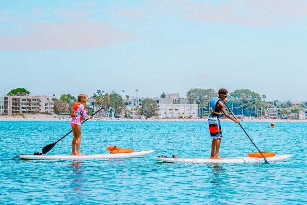 a group of people rowing a boat in the water