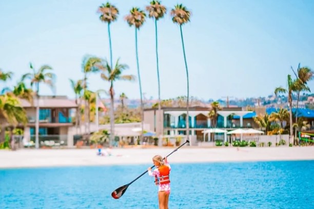 a man riding on the back of a boat in a body of water