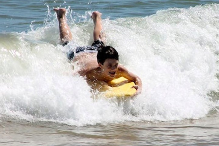 a young girl riding a wave on a surfboard in the ocean