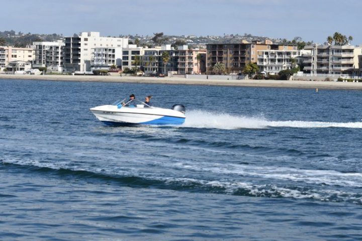 a small boat in a body of water with a city in the background