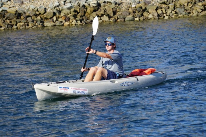 a man riding on the back of a boat in a body of water