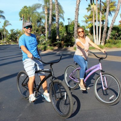 a little girl riding on the back of a bicycle