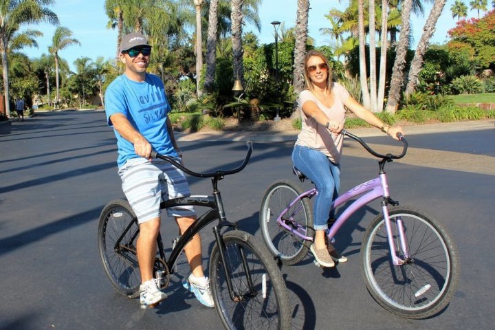a little girl riding on the back of a bicycle