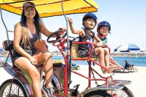 a man and a woman sitting on a bicycle