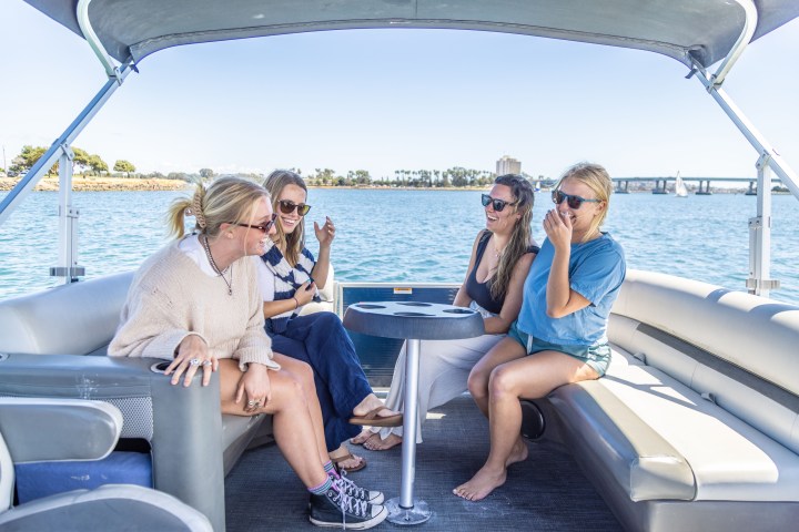 a woman sitting on a dock next to a body of water
