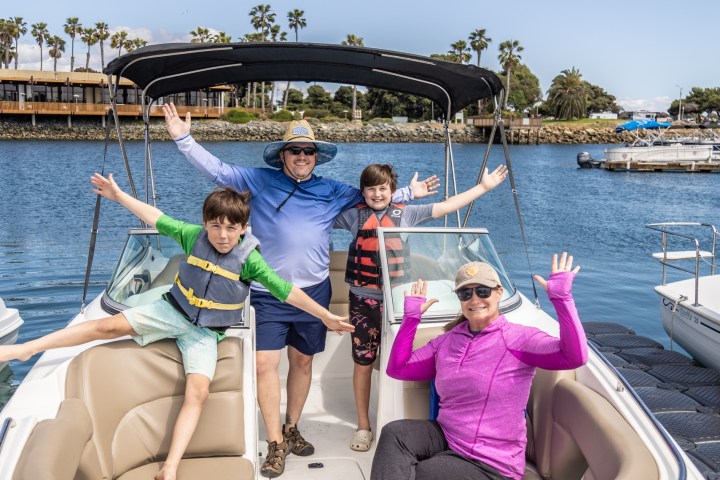 a group of people sitting in a boat on a body of water